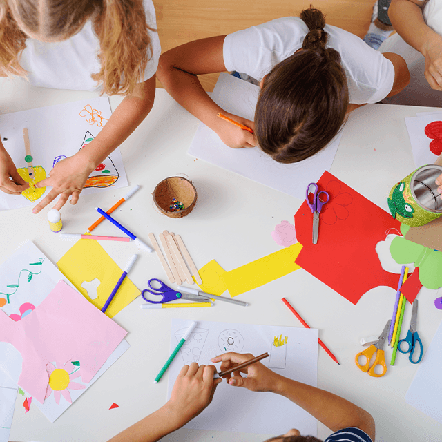 Children drawing and crafting together on the floor