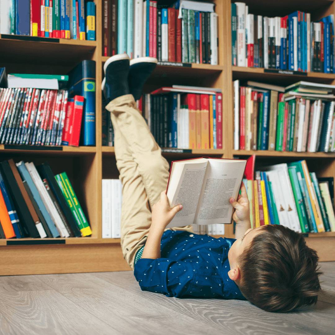 Pojke som läser på rygg – stillsamma aktiviteter med barn Stockholm på bibliotek