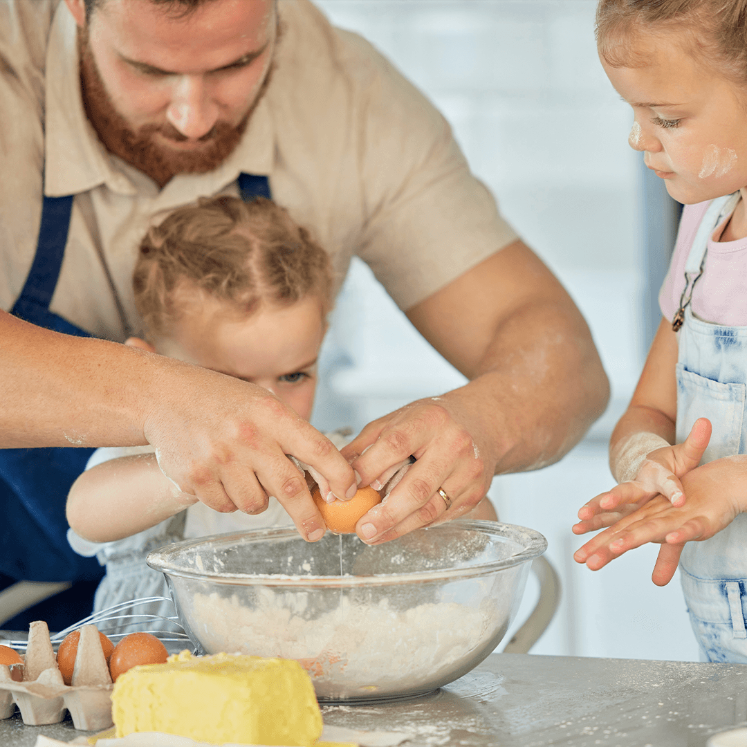 Pappa och barn bakar tillsammans – aktiviteter en regnig dag hemma.