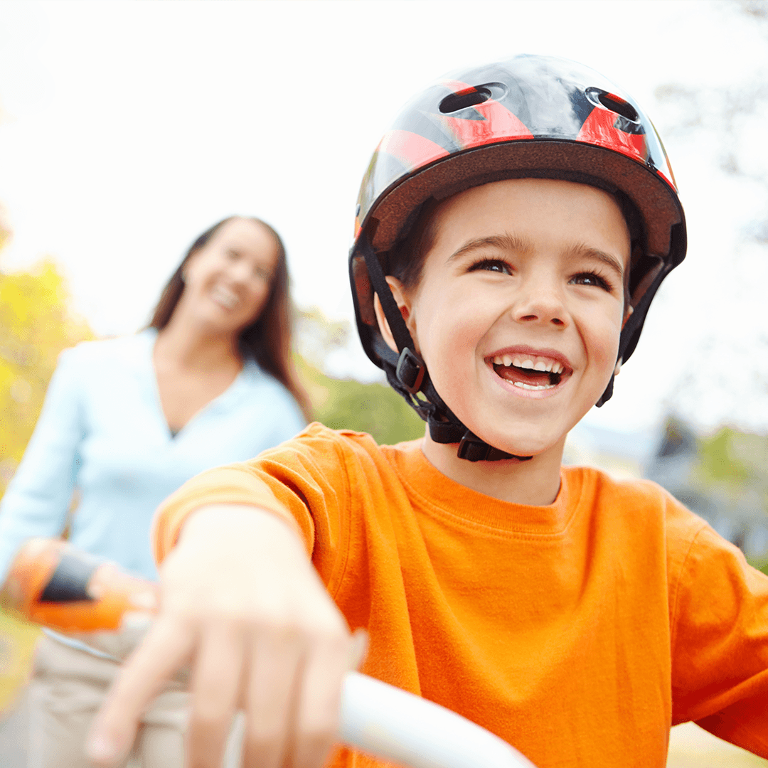 Pojke och mamma cyklar tillsammans – barn och rörelse i naturen