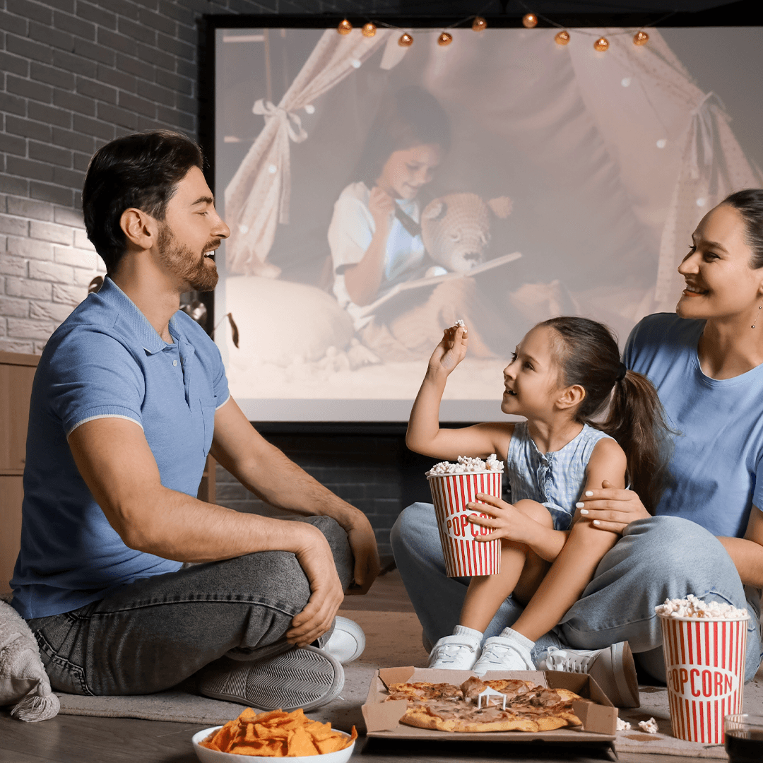 Familj myser med film och snacks – att göra med barn en regnig dag.