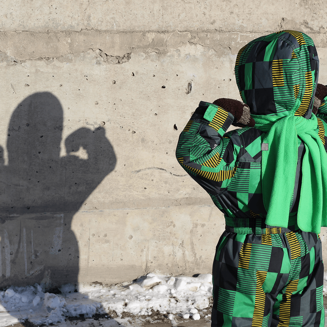 Child creating shadow shapes outdoors during winter break play