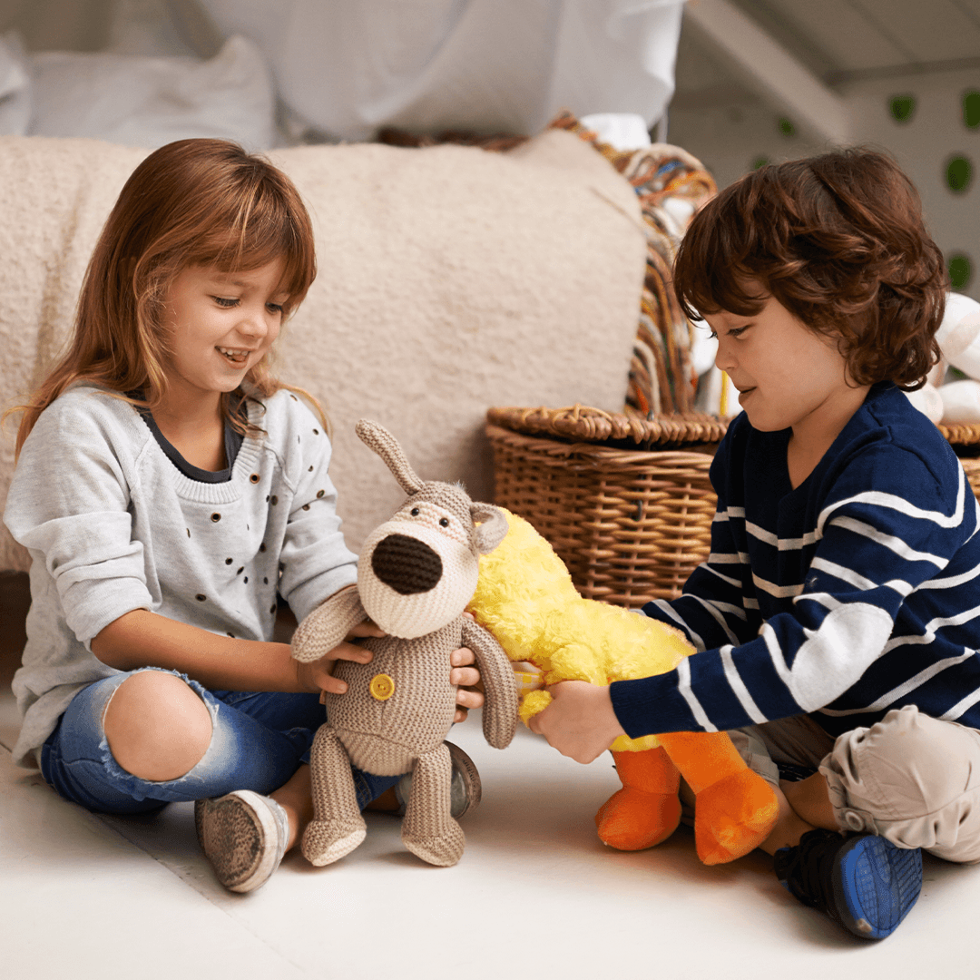 Girl and boy playing with stuffed animals during a winter break indoor activity